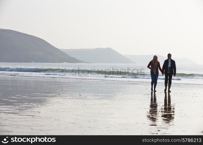 Senior Couple Walking Along Winter Beach