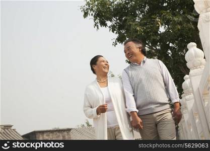 Senior couple walking outside in Beijing, tilt