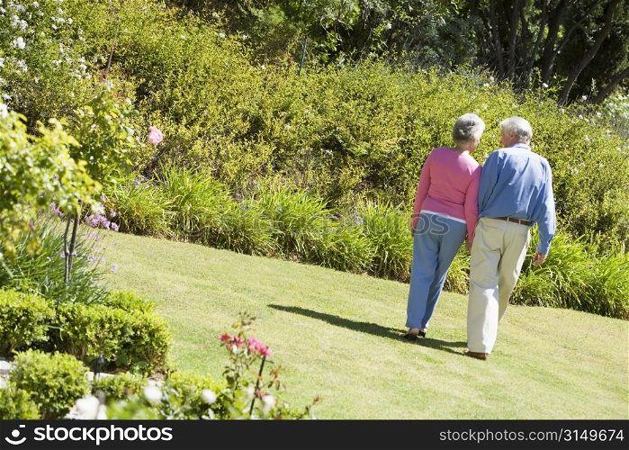 Senior couple walking through a flower garden