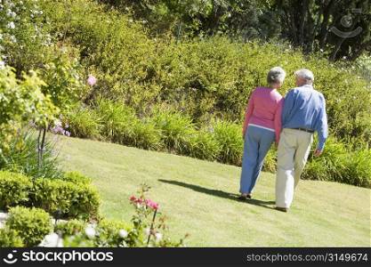 Senior couple walking through a flower garden