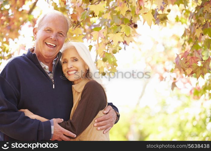 Senior Couple Walking Through Autumn Woodland