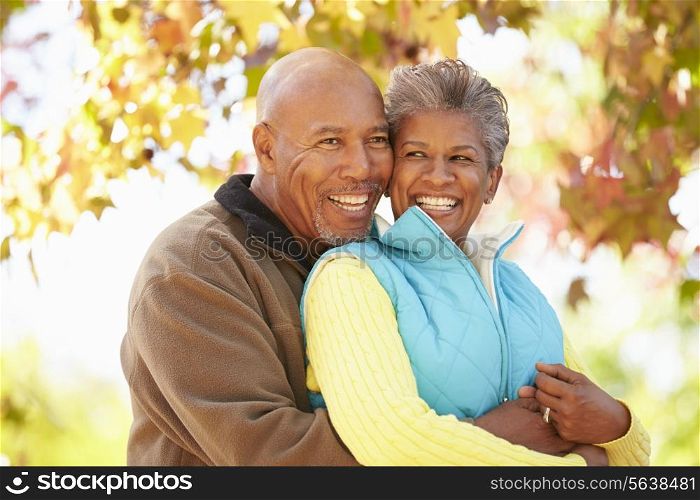 Senior Couple Walking Through Autumn Woodland