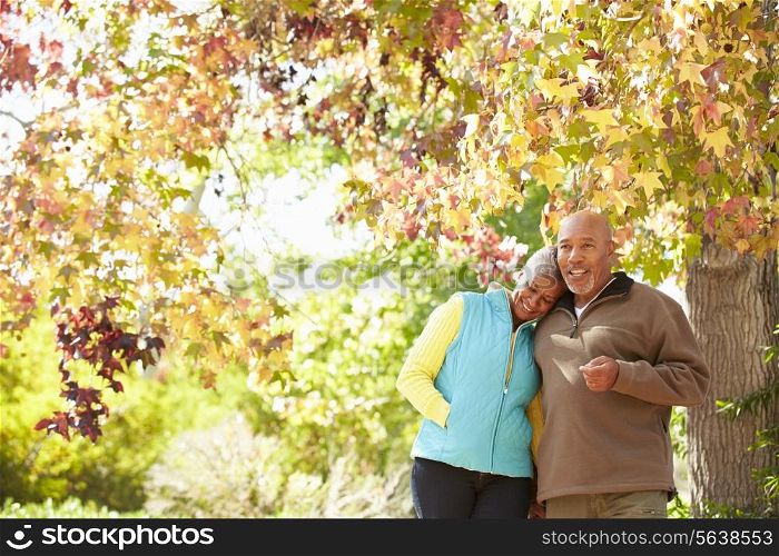 Senior Couple Walking Through Autumn Woodland