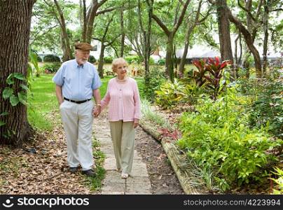 Senior couple walking through the park together.