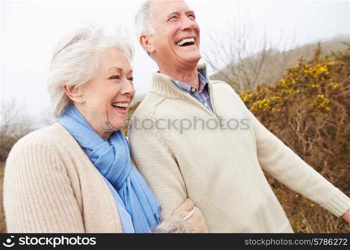 Senior Couple Walking Through Winter Countryside
