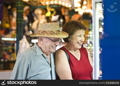 Senior couple watching window display, smiling