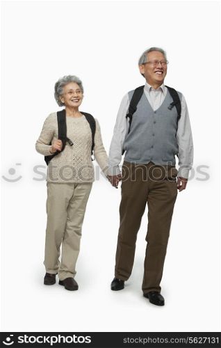 Senior couple with backpacks walking