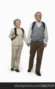 Senior couple with backpacks walking