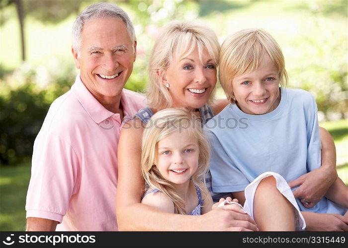 Senior couple with children posing in park