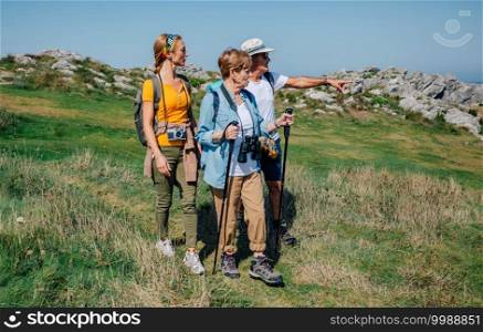 Senior couple with their daughter practicing trekking outdoors. Family practicing trekking together outdoors