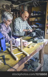 Senior couple working in a carpentry workshop. Senior couple in a carpentry