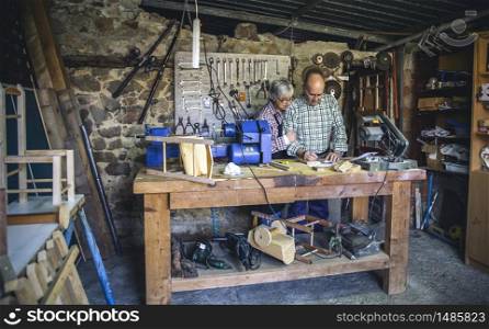 Senior couple working in a carpentry workshop. Senior couple in a carpentry