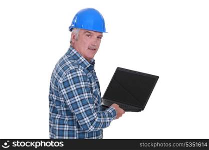 senior craftsman holding a laptop