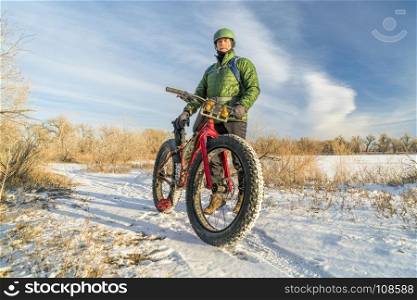 senior cyclist is riding a fat bike in winter, cold day in Colorado