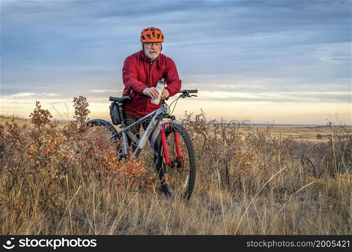 senior cyclist is riding mountain bike in Colorado prairie - Soapstone Prairie Natural Area with last fall colors in late October