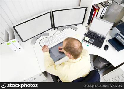 Senior designer, using a graphic tablet, at work in an office