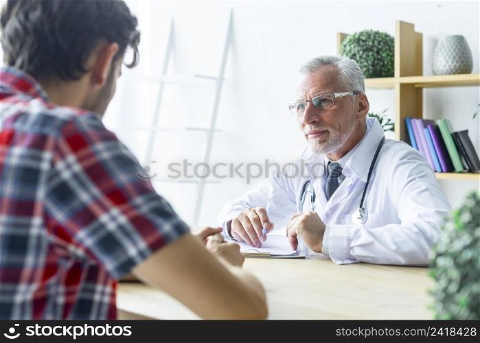 senior doctor listening patient closely