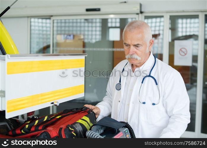 senior doctor next to an ambulance