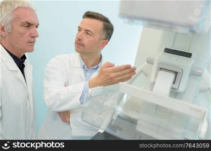 senior doctors discussing next to machine in hospital