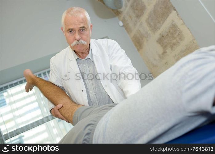 senior doing rehabilitation physiotherapy on patient