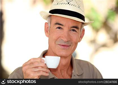 senior drinking coffee outdoors