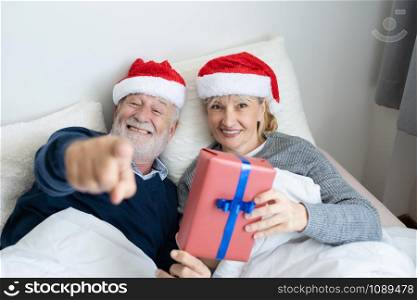senior elderly caucasian old man and woman give gift or present for christmas festival day in the morning, retirement lovely couple lifestyle concept