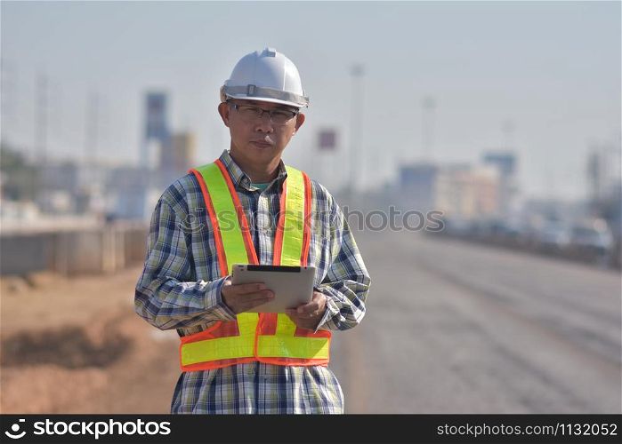 Senior Engineering worker by tablet inspection on site road construction