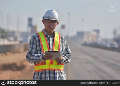 Senior Engineering worker by tablet inspection on site road construction