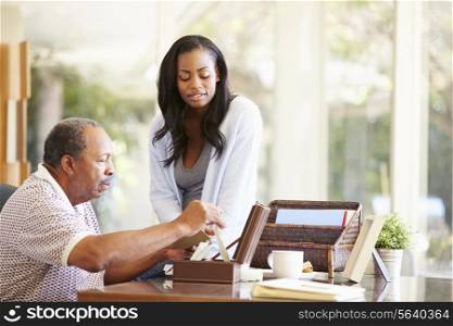 Senior Father Discussing Document With Adult Daughter