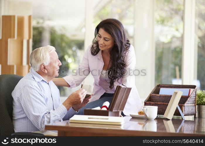 Senior Father Discussing Document With Adult Daughter