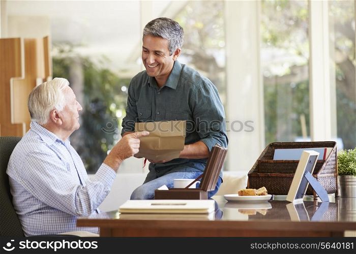 Senior Father Discussing Document With Adult Son