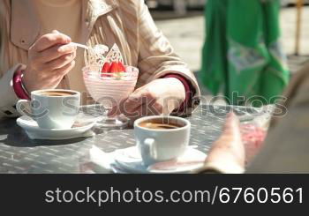 Senior Female Friends Eating Dessert At Outdoor Cafe