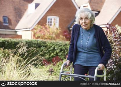 Senior Female In Garden Using Walking Frame