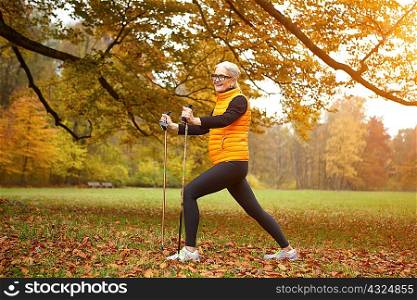 Senior female nordic walker exercising in park