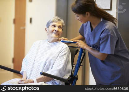 Senior Female Patient Being Pushed In Wheelchair By Nurse