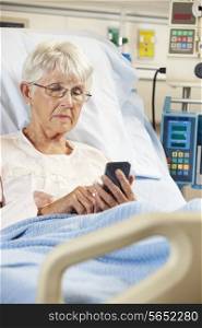 Senior Female Patient In Hospital Bed Using Mobile Phone