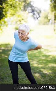 Senior fitness woman rubbing the muscles of her lower back. Back pain