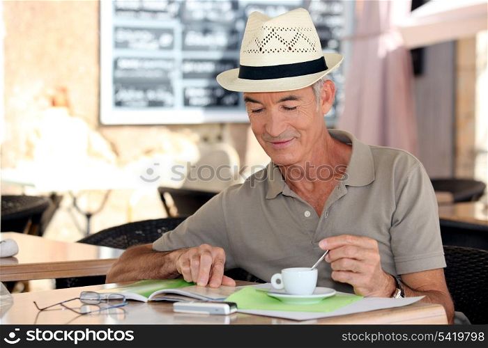 senior gentleman enjoying free time in cafe