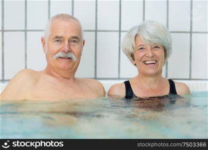 senior happy couple in swimming pool