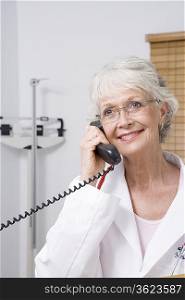 Senior healthcare professional holds telephone receiver