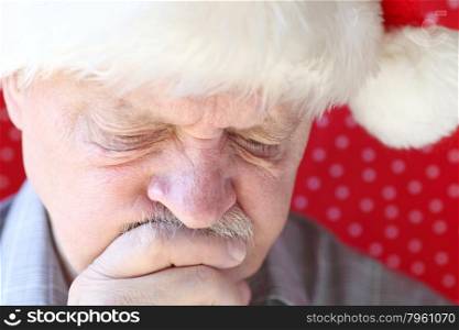 senior in holiday hat is lost in thought