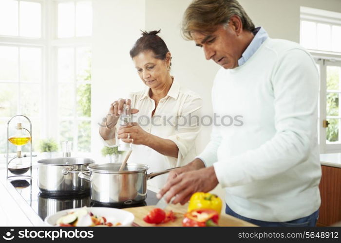 Senior Indian Couple Cooking Meal At Home