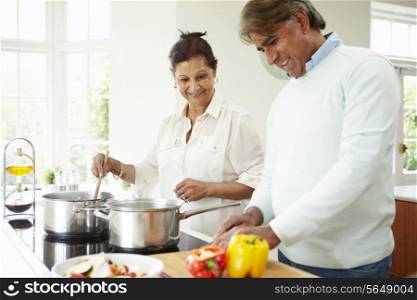 Senior Indian Couple Cooking Meal At Home