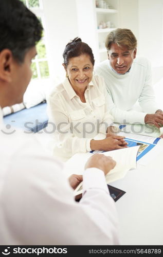 Senior Indian Couple Meeting With Financial Advisor At Home