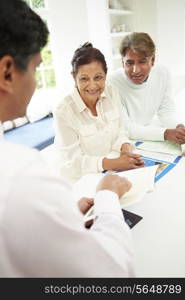 Senior Indian Couple Meeting With Financial Advisor At Home