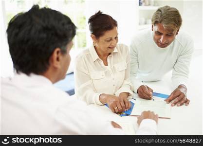 Senior Indian Couple Meeting With Financial Advisor At Home
