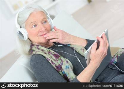 Senior lady listening to music through headphones