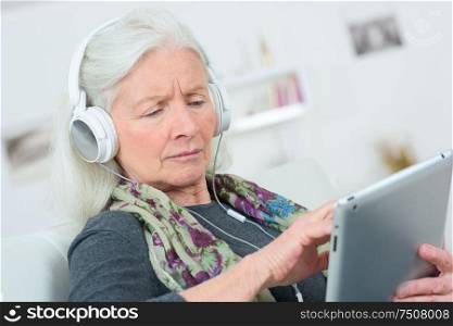 Senior lady listening to music through headphones