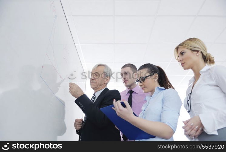 Senior male business man giving a presentation at a meeting at modern light office on a table board