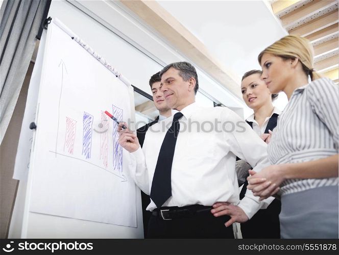 Senior male business man giving a presentation at a meeting at modern light office on a table board
